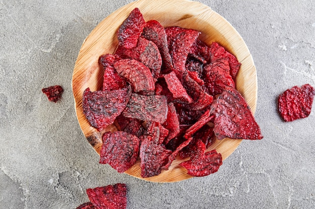 Dried beetrott chips on wooden bowl