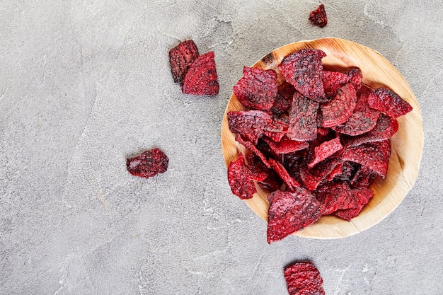 Dried beetrott chips on wooden bowl