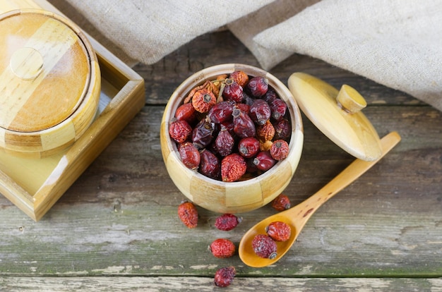 Dried berries in the pot with spoon on old wooden table