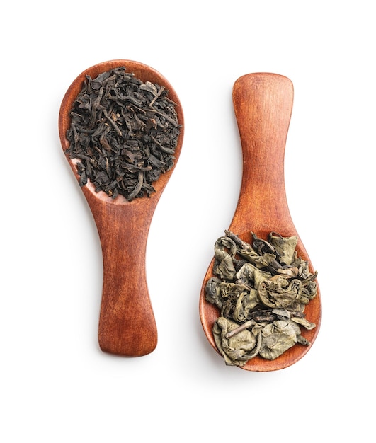 Dried black and green tea leaves in wooden spoon