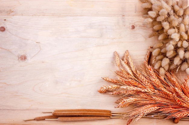 Photo dried bread spikes on wooden table autumn harvest of bread