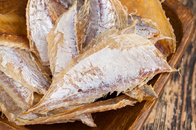 Dried and butchered small fish on a wooden table