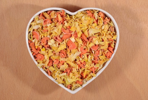 Dried carrots and onions in plate in the form of heart