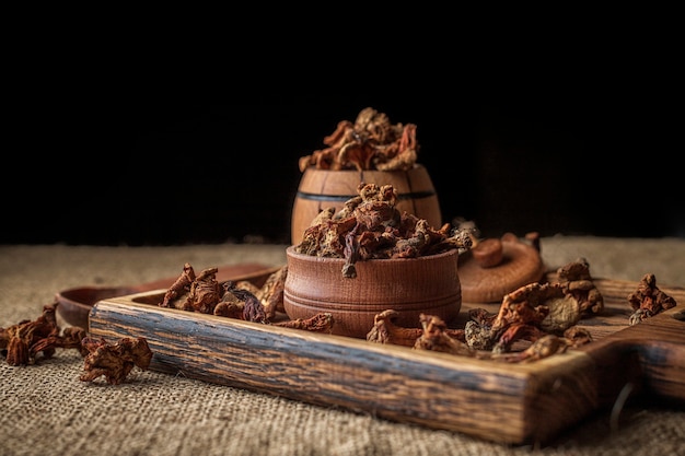 Dried chanterelle mushrooms (CantharÃÂllus cibÃÂrius), on a wooden board, on a rough woven surface, burlap