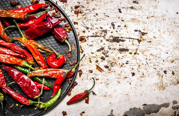 Foto peperoncino essiccato sul vassoio sul tavolo rustico. vista dall'alto