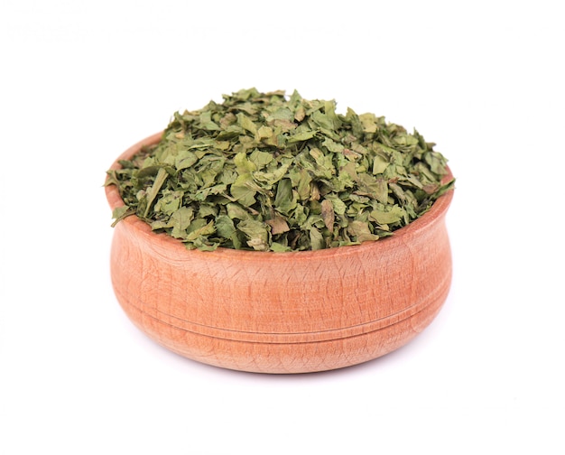 Dried cilantro in wooden bowl