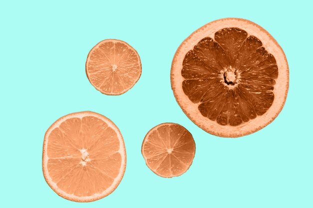 Dried citrus chips over background of peach fuzz color trendy color of 2024 year flat lay top view