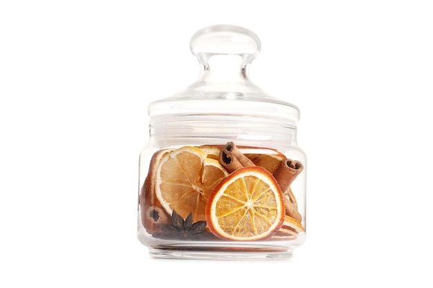 Dried citrus fruits with cinnamon and star anise in a bottle isolated on a white background. Storage concept. Holidays. Scenery.