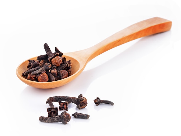 Dried cloves spoon on white background