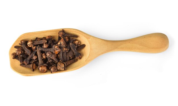 dried cloves in the wooden spoon, isolated on white