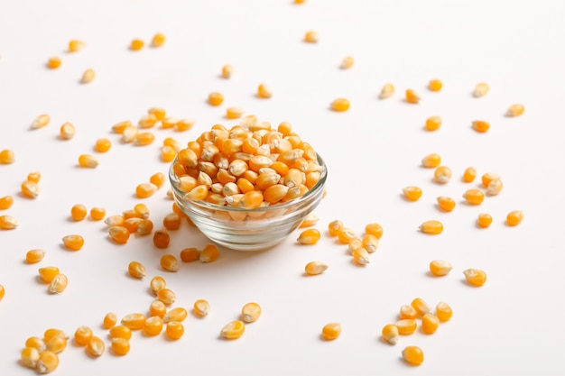 Dried corn seeds in bowl on white  