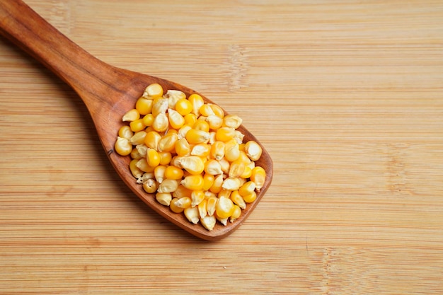 Dried corn seeds in wooden spoon