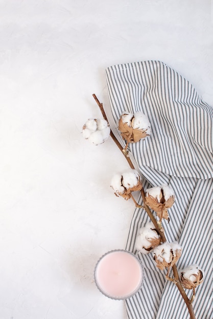 Dried cotton branch, candle on Crumpled Striped Napkin