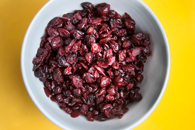 Dried cranberries in white bowl. Ingredients for healthy breakfast. 