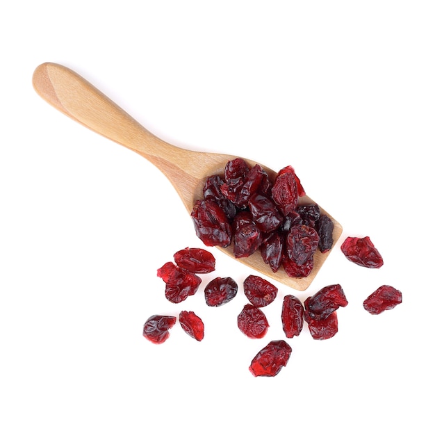 Dried cranberries on wooden spoon isolate on white