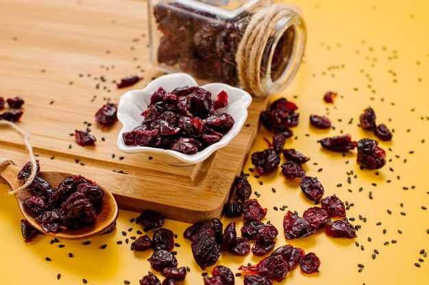 Dried cranberry scattered on yellow background