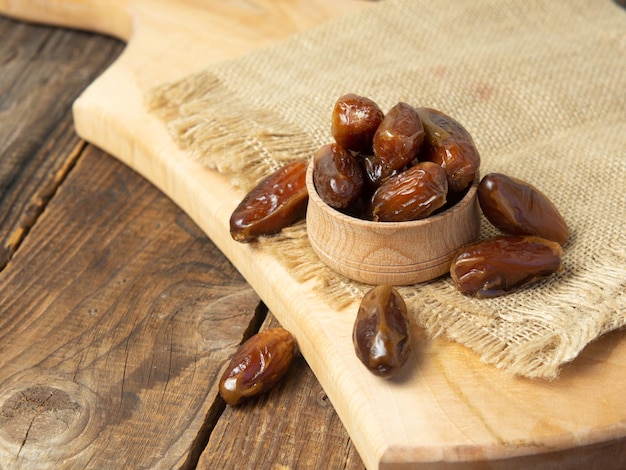 Dried date fruit in bowl on the old wooden table