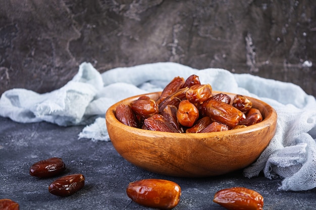 Dried date fruit in bowl on wooden. Delicious dates fruit