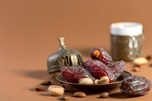 Dried dates are a popular dessert for Arabic black coffee in a traditional bronze dish