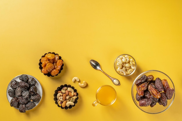 Dried dates fruit and apricot on yellow background