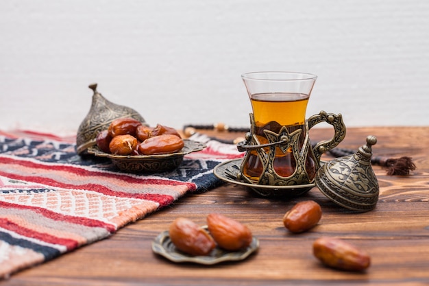 Photo dried dates fruit with glass of tea