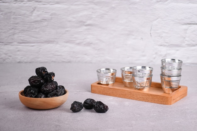 Dried dates in a wooden bowl on concrete background