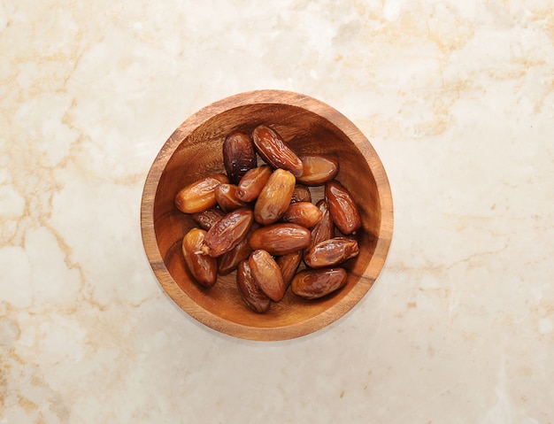 Dried dates on a wooden bowl