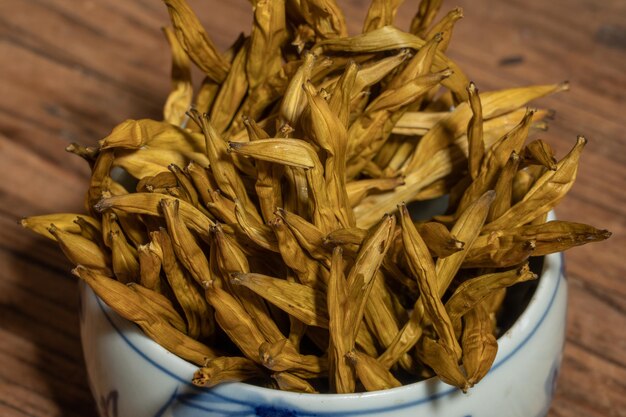 Dried day lily in a container on a wooden countertop