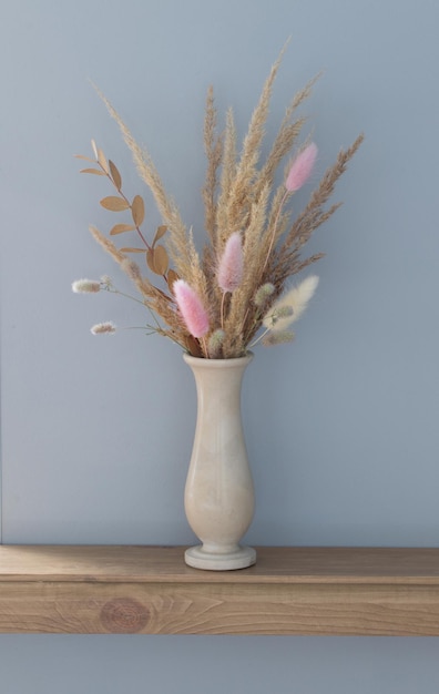 dried decorative cereals in  vase on  wooden shelf