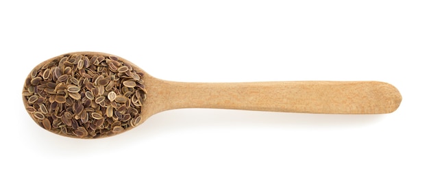 dried dill seeds in spoon isolated on white