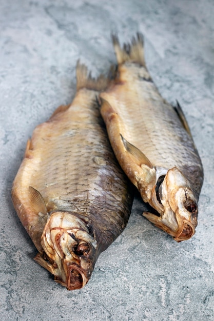 Dried dried golden fish, river fish, lies on a gray table