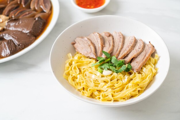 白いボウルに乾燥したアヒルの麺-アジア料理スタイル