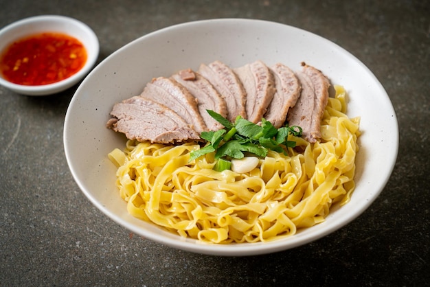 Dried duck noodles in white bowl