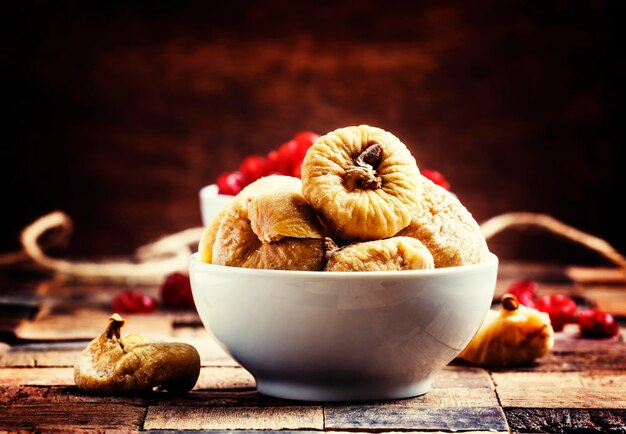 Dried figs and sweet cherry vintage wooden background selective focus