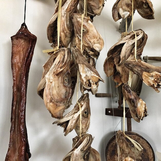 Photo dried fish hanging against wall at shop