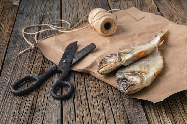 テーブルの上の干物。暗い背景の木に塩辛い川の魚