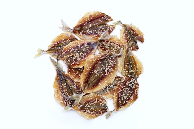 Dried fish with sesame seeds on white background