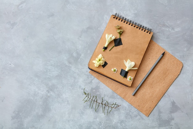 Dried flower on notebook with copy space on a stone background, flat lay