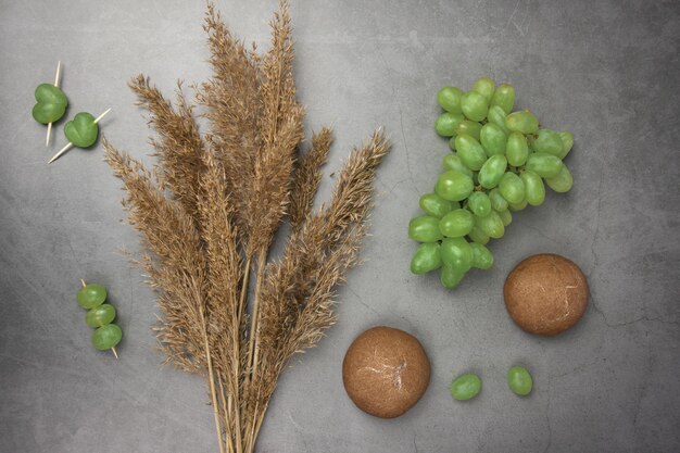 dried flowers chocolate gingerbread and fresh green grapes lie on a white background closeup