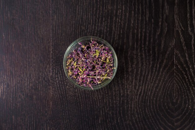 Dried flowers in a glass bowl - top view. On a black background. Still life. Copy space