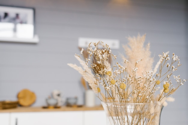 Dried flowers in a yellow vase close-up. Cozy home decor. Copy space