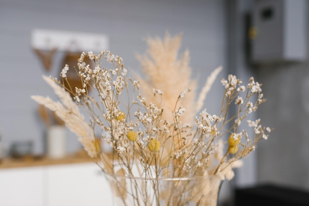 Dried flowers in a yellow vase close-up. cozy home decor