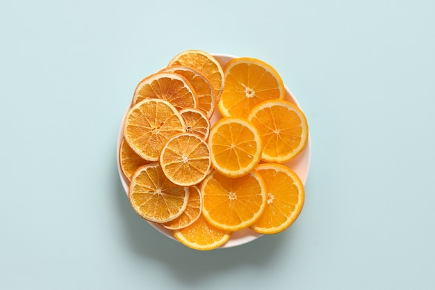 Dried and fresh orange chips on blue