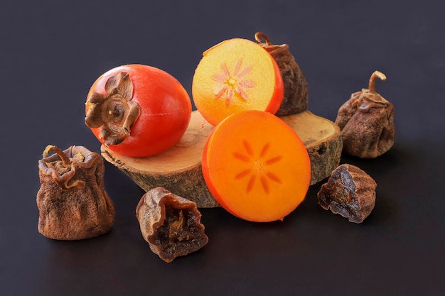 Dried and fresh persimmons on a black background Its Turkish name is persimmon