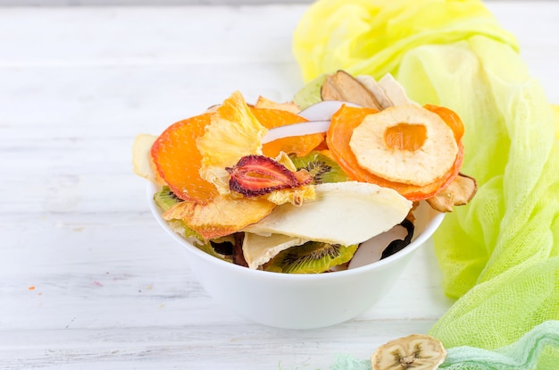 Dried fruit in plate on wooden white 