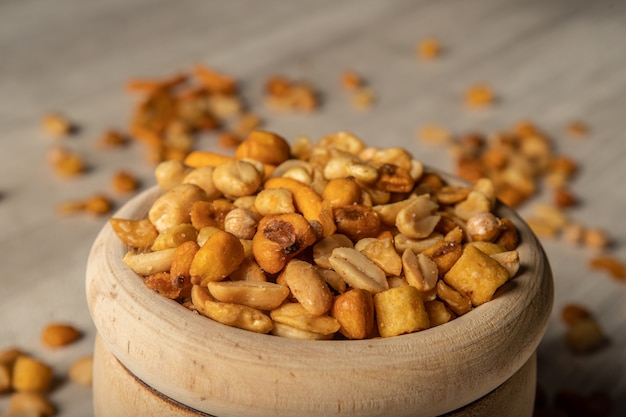 Foto frutta secca in una ciotola di legno, spuntino tra i pasti