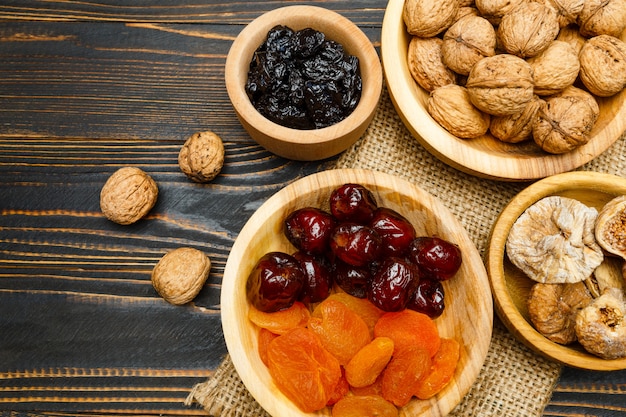 Dried fruits figs, apricots, plums and nuts on wooden table