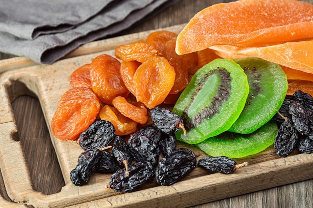 Dried fruits and napkins Old kitchen board and wooden table