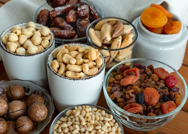 Dried fruits and nuts close up. Selective focus. Organic and healthy. Trail mix of almond, macadamia, pine, Brazil edible nuts, hazelnut, dates, dried apricots