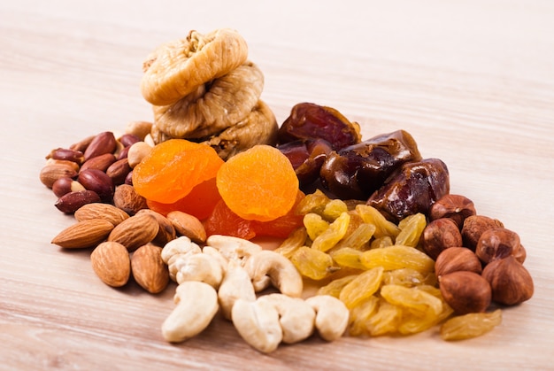 dried fruits and nuts heaps on wooden table